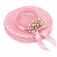 Pink abaca doll hat decorated with lace trim, narrow satin ribbon tails, and baby's breath flowers, demonstrating a completed hat embellishment for a handmade doll pin doll.
