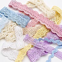 Assorted lace trims in a variety of colors and styles, including crocheted scalloped lace, embroidered lace, eyelet lace, and blue rickrack, loosely arranged on a white background for doll making, sewing, quilting, and decorative craft projects.