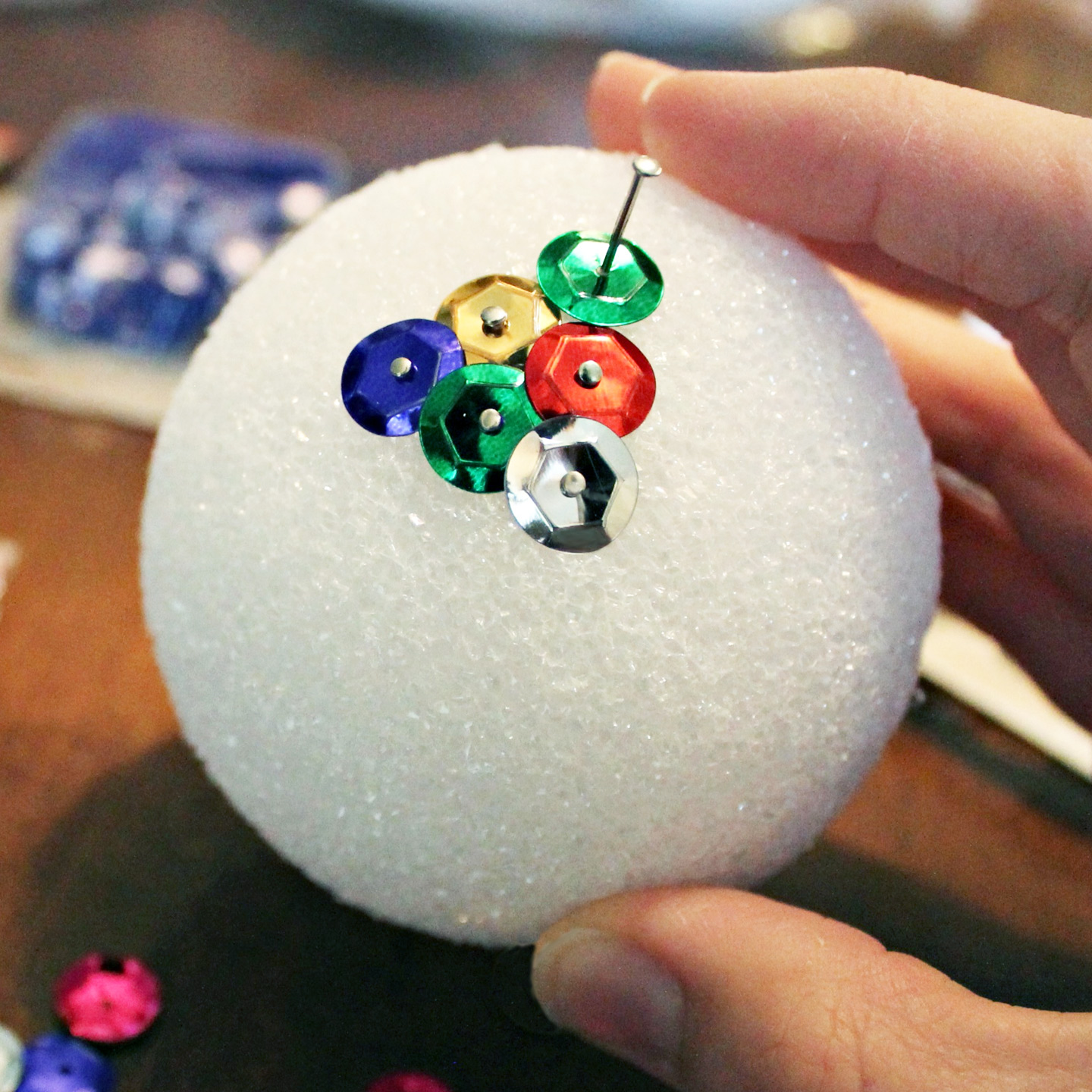 Pinning the sequin to the styrofoam ball - Sequin Christmas Ornament